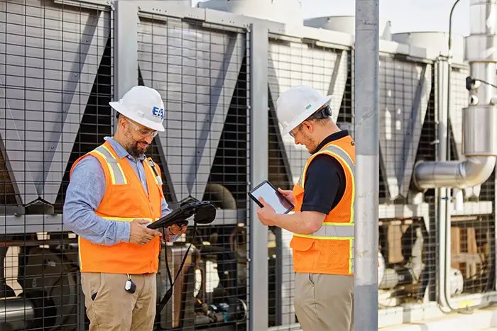 Field engineer performing HVAC diagnostics on industrial rooftop equipment